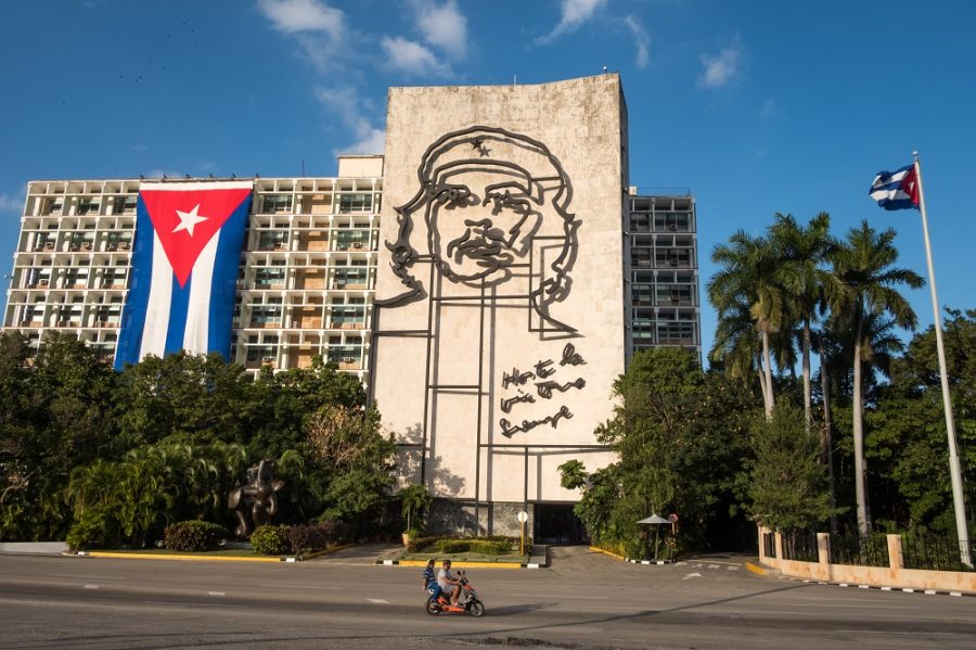 CUBA TWO PEOPLE PASS IN FRONT OF THE MINISTRY OF THE INTERIOR